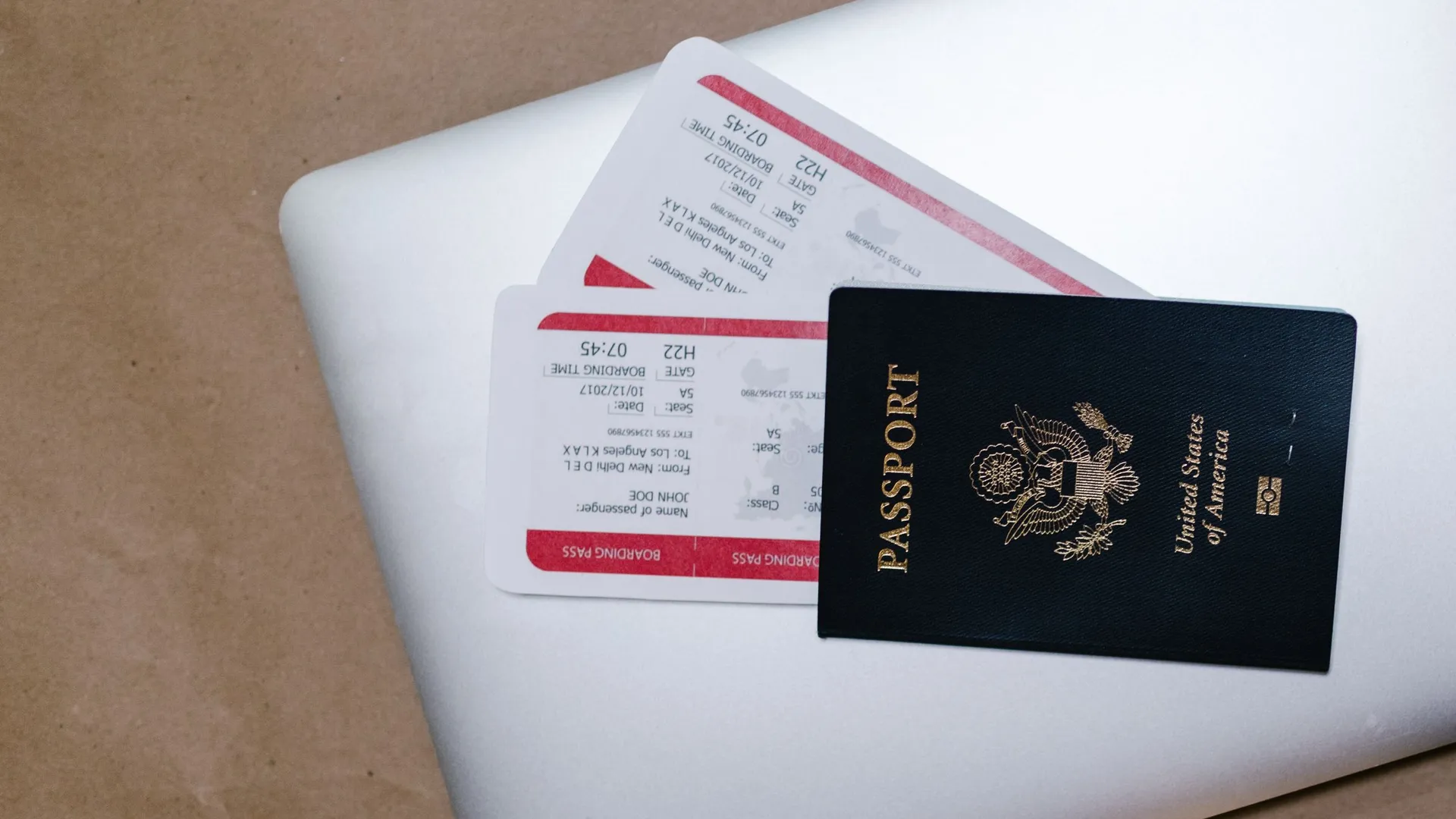 Pasaporte y tarjetas de embarque sobre el portátil, listos para rellenar el formulario antes del vuelo